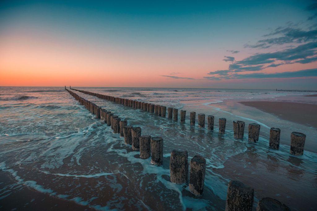 Golfbrekers bij zonsondergang