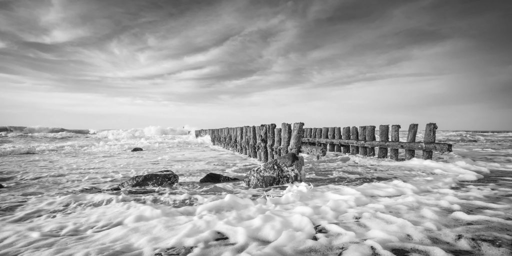 Schuimende zee in zwart-wit